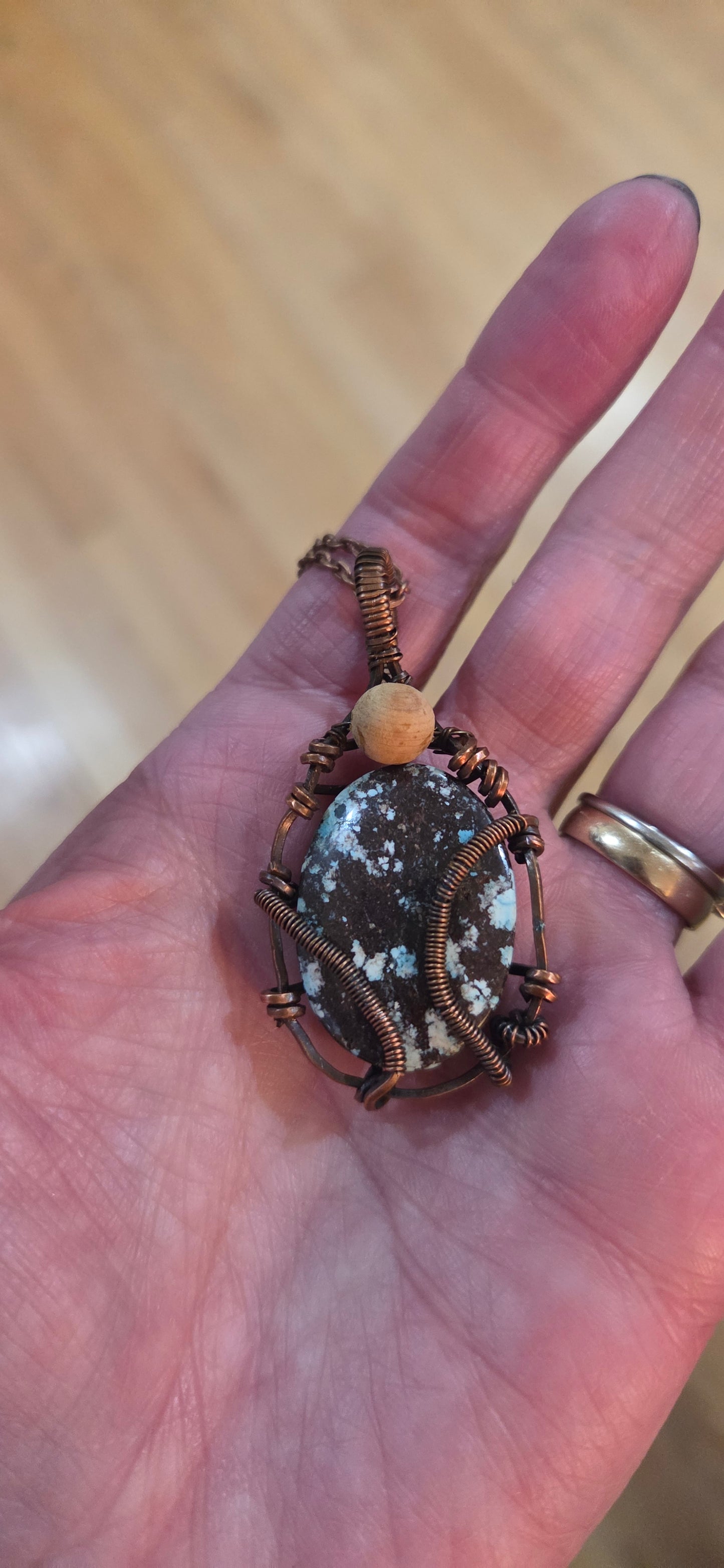 Turquoise pendant wrapped in aged copper